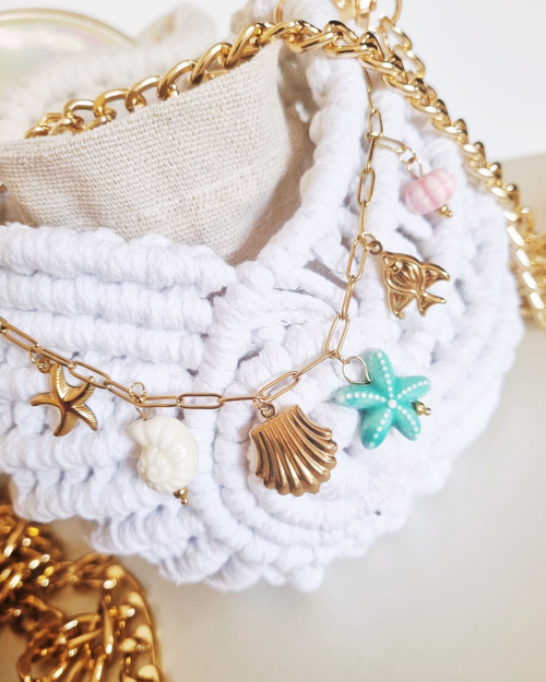 Bolsa Búzio Branca - detalhe dos charms: concha, estrela do mar turquesa e pérolas