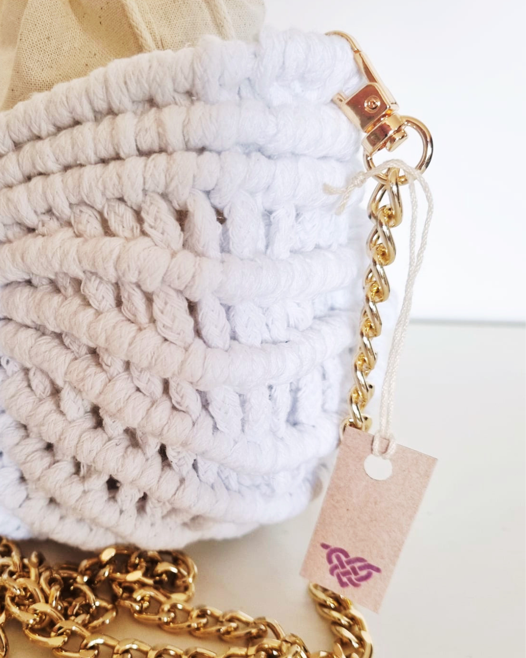 Bolsa Búzio Branca - detalhe da textura em macramé e alça dourada