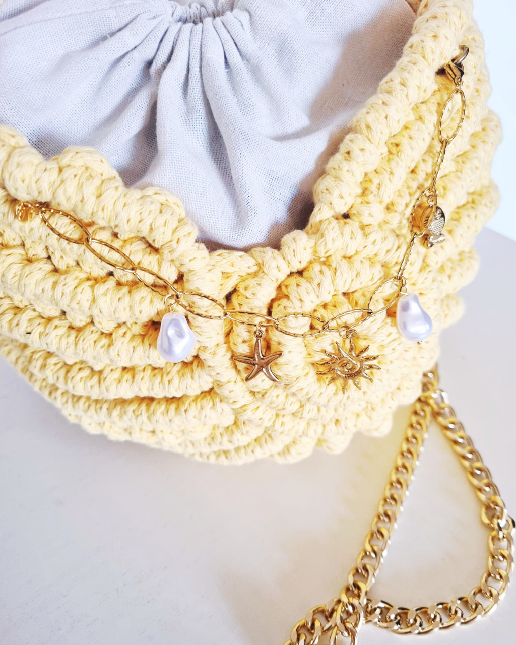 Bolsa Búzio Amarelo Manteiga - vista lateral com saco interior em linho e alça dourada