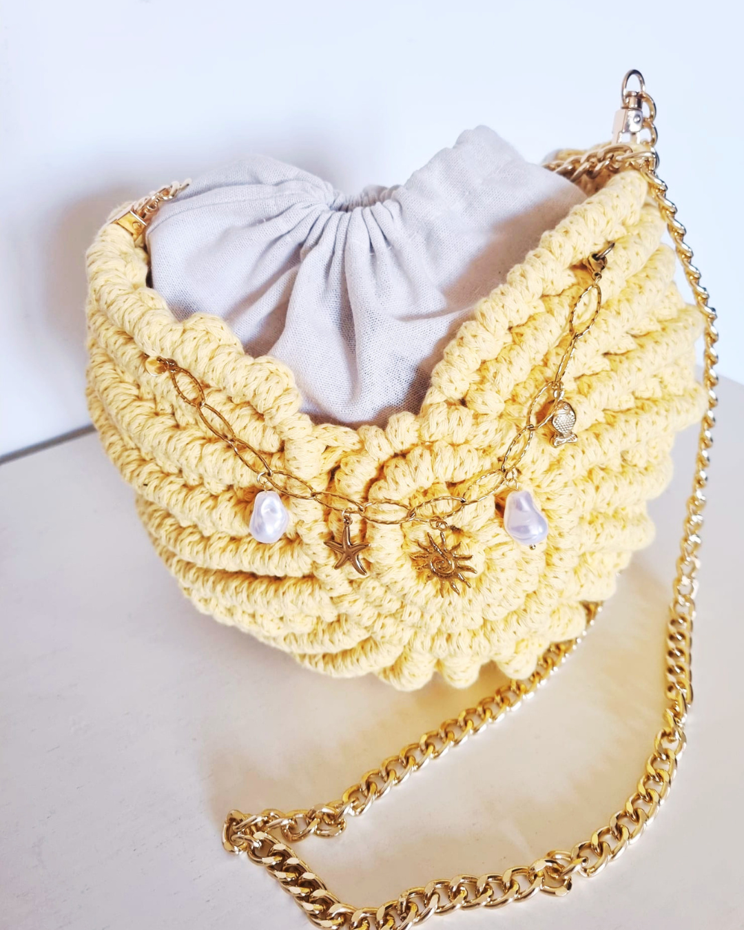 Bolsa Búzio Amarelo Manteiga - detalhe do fecho e alça de aço dourado