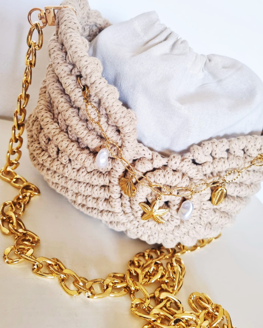 Bolsa Búzio Natural com Charms Marinhos - detalhe da corrente dourada e charms marinhos