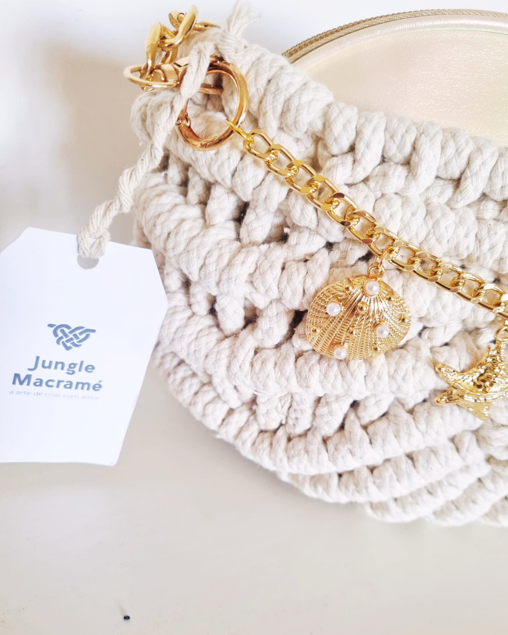Bolsa Búzio Natural - detalhe dos charms: estrela do mar e concha dourada