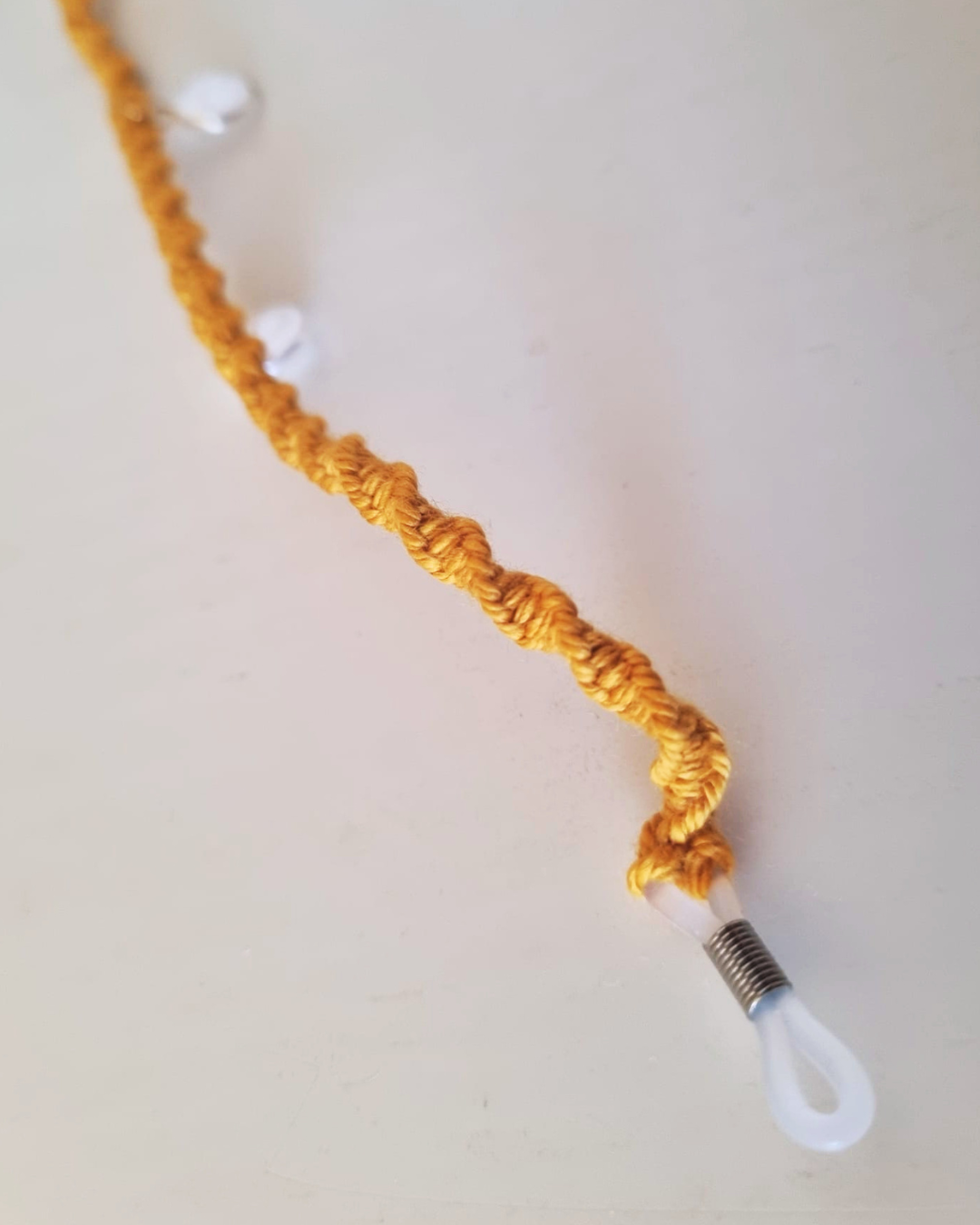Fita de óculos artesanal mostarda - detalhe do terminal de silicone