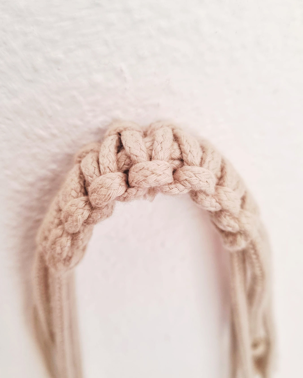 Detalhe do nó artesanal em algodão natural bege