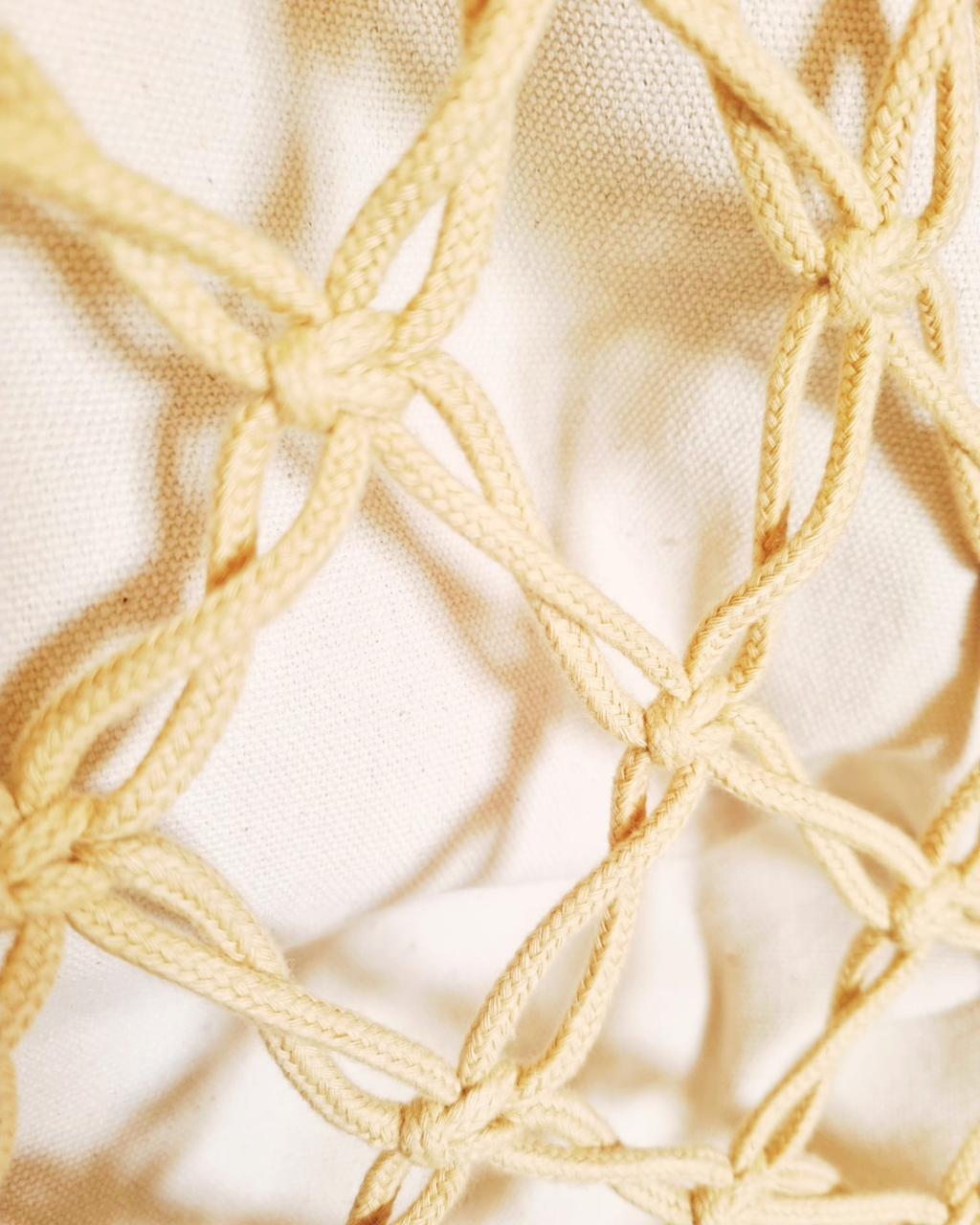 Detalhe do padrão de nós em macramé cor areia natural