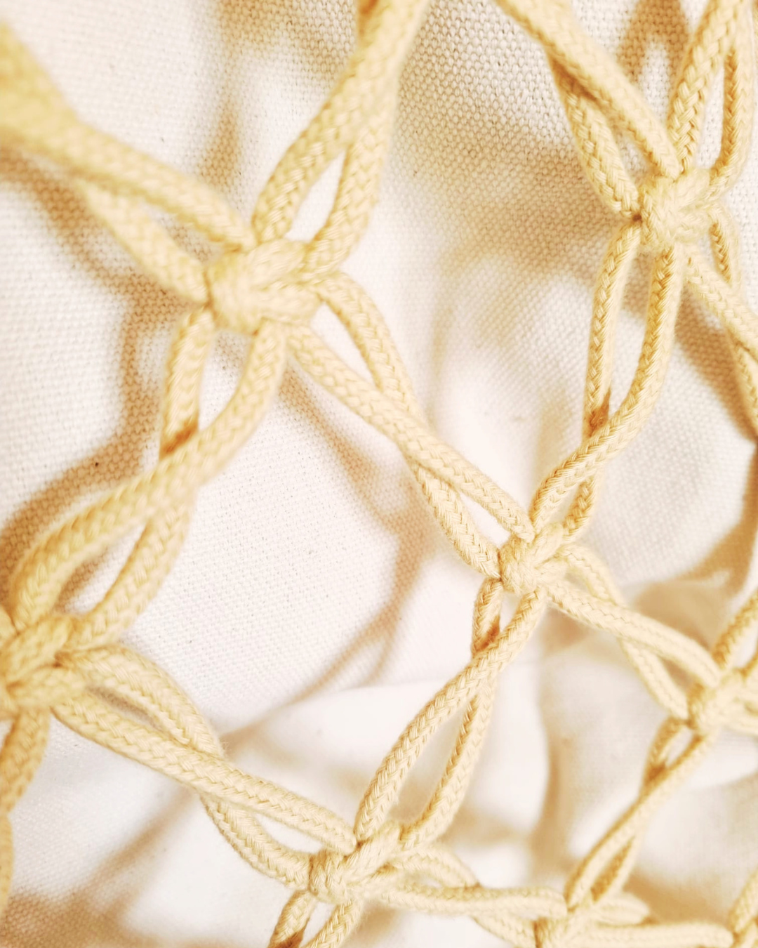 Detalhe do padrão de nós em macramé cor areia natural