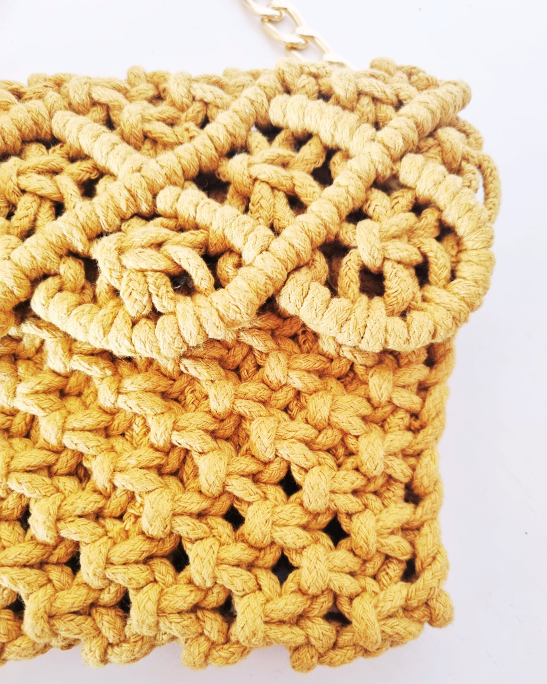 Detalhe do padrão de nós em macramé amarelo mostarda