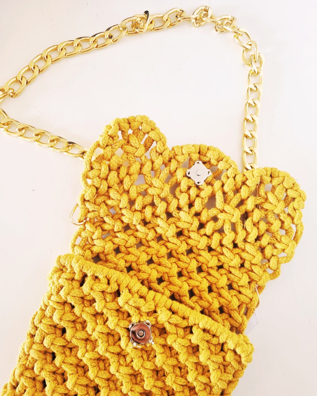 Detalhe do fecho magnético da bolsa em macramé amarela