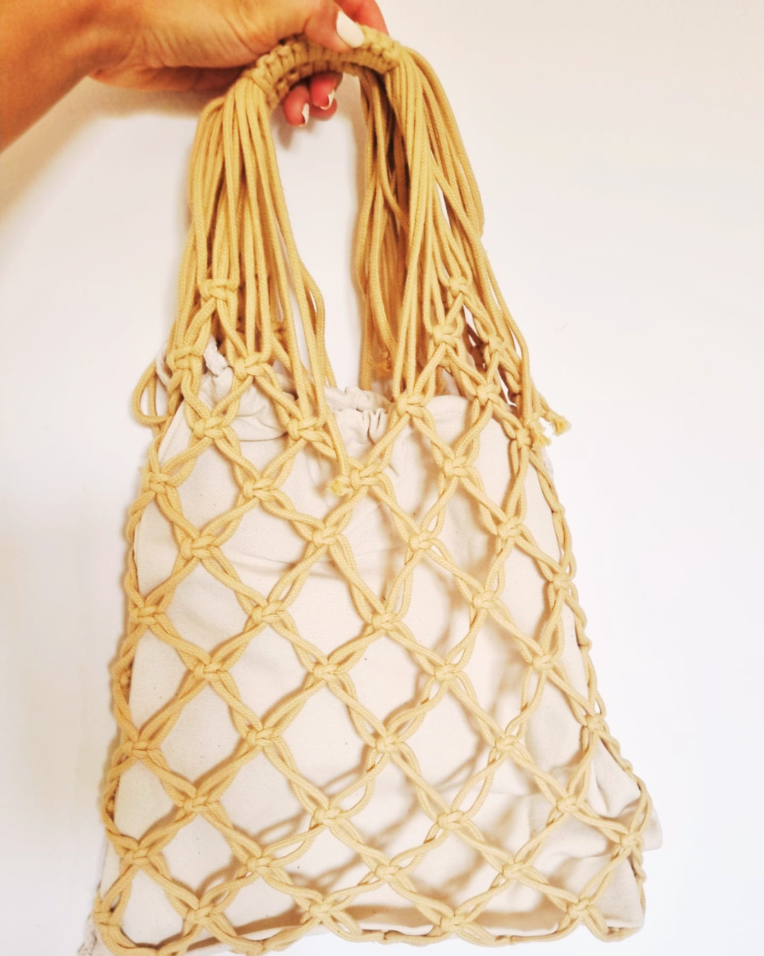 Eco bag em macramé areia - modelo a segurar a mala