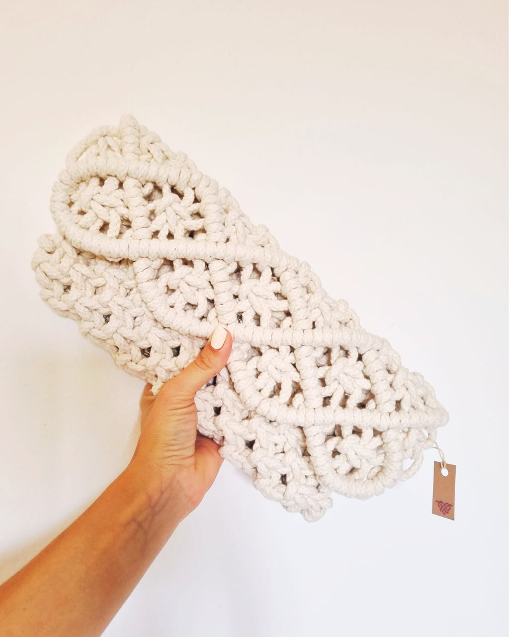 Clutch em fio entrançado cru - modelo a segurar a peça aberta