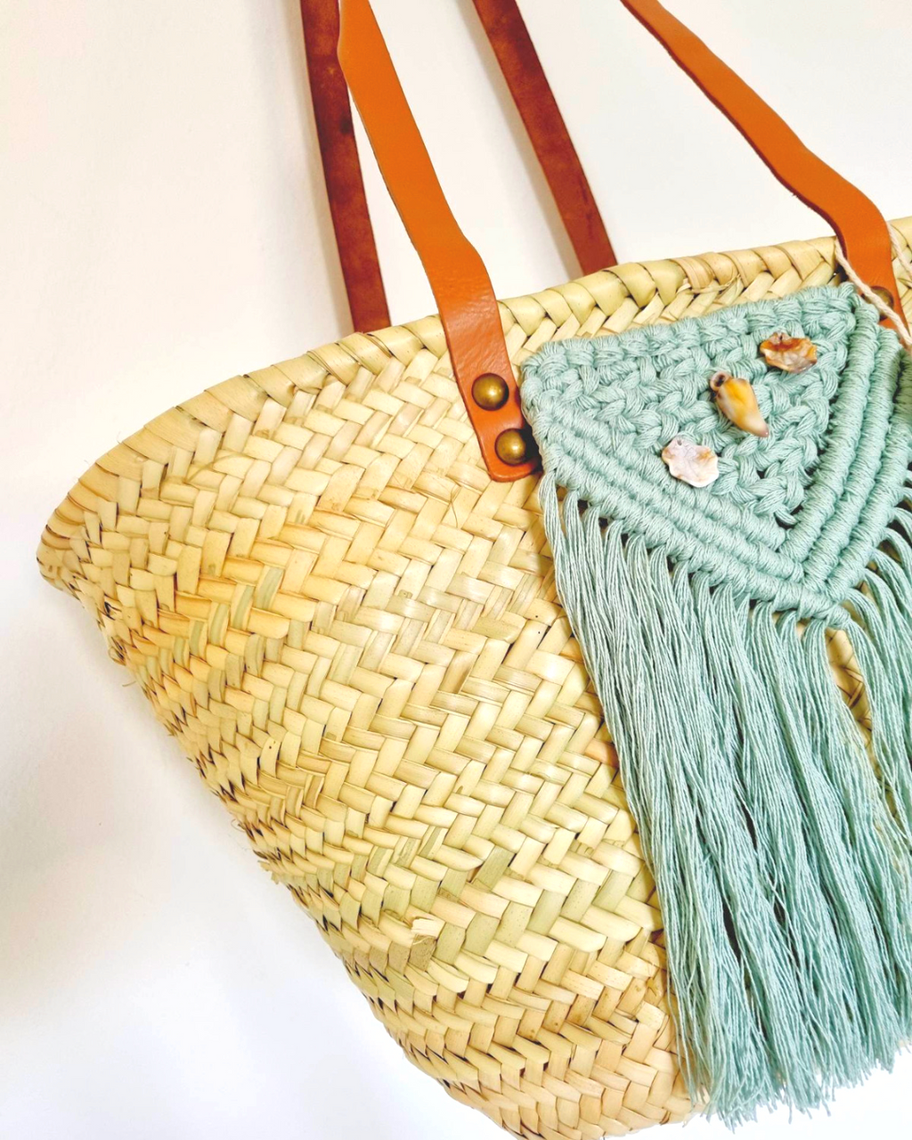 Cesta de praia em palha com aplicação de macramé azul turquesa e algas em pele — detalhe frontal