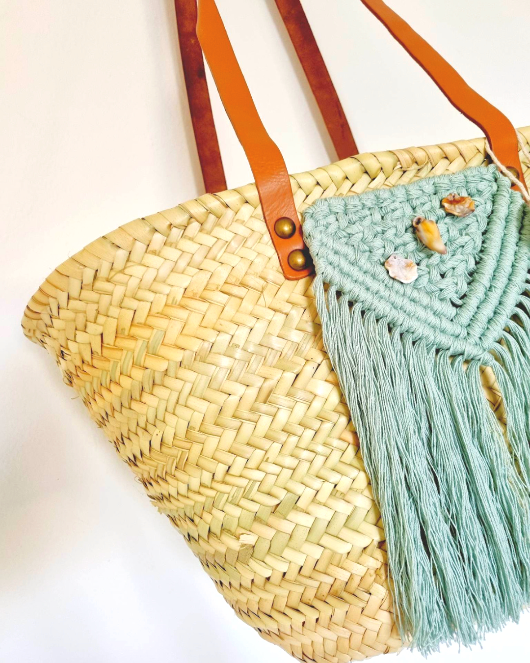 Cesta de praia em palha com aplicação de macramé azul turquesa e algas em pele — detalhe frontal
