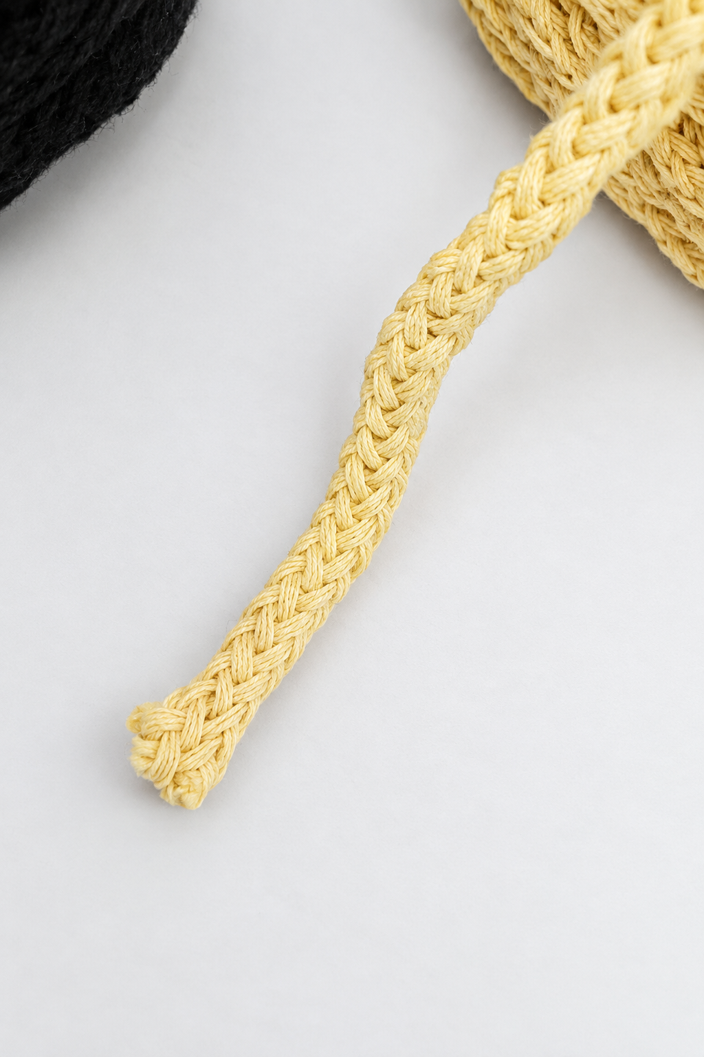 Detalhe do entrançado do fio amarelo manteiga para macramé